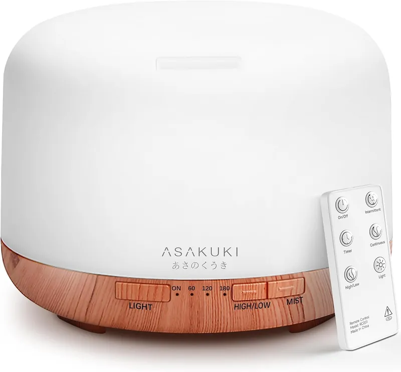 white diffuser with wood base, buttons, and a small remote control. Best Essential Oil Diffusers for Yoga Rooms: 10 Options That Create a Calming Atmosphere