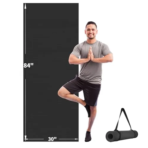 extra long wide yoga mat stands beside a man in tree pose. 9 Best Extra Long Yoga Mats for Tall Yogis Who Need Full-Body Coverage
