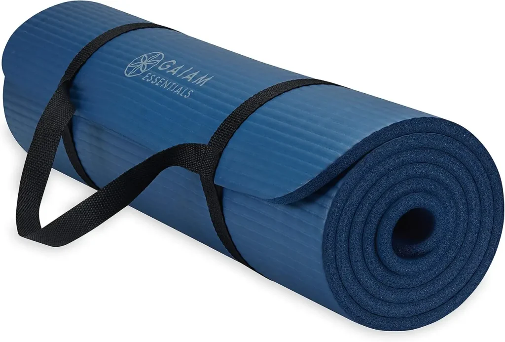 The Gaiam thick navy yoga mat sits tightly rolled with its easy cinch strap threaded through the core.