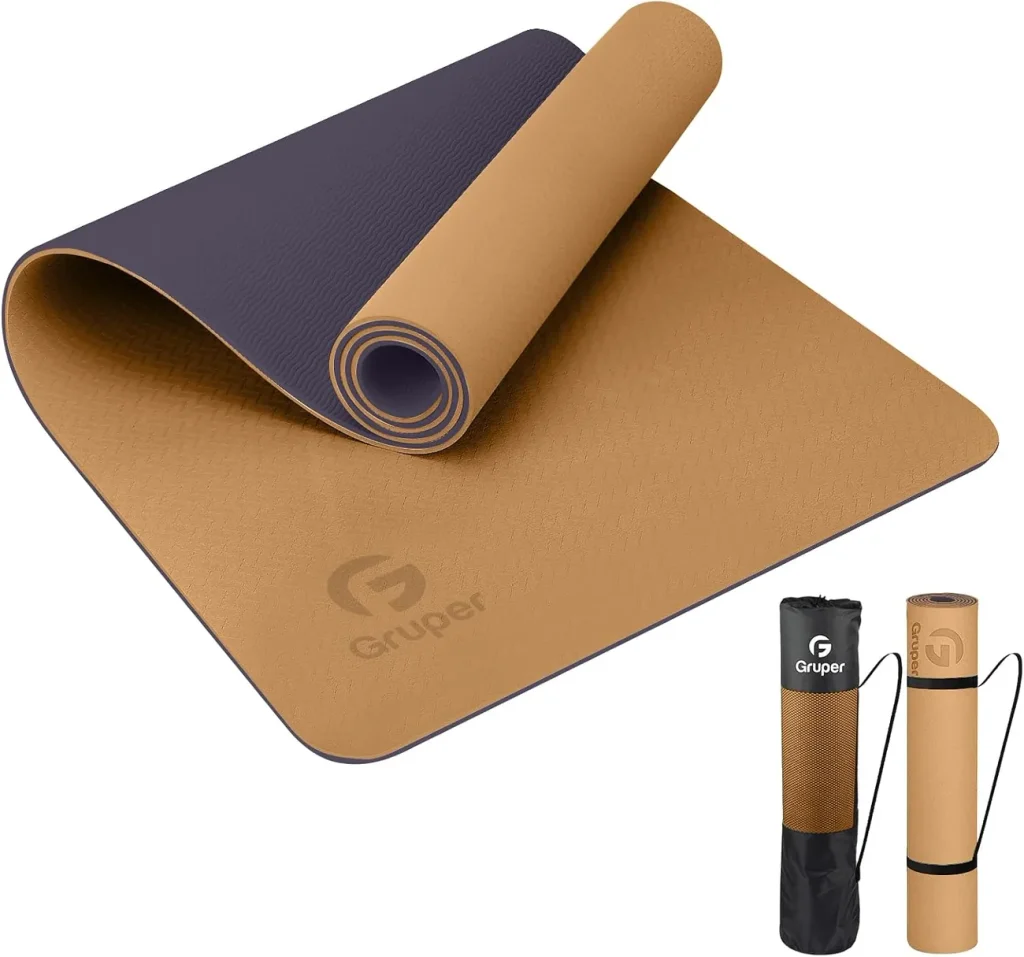The Gruper thick TPE mat in champagne gold and brown lies flat with its rolled form showing the two layer build.