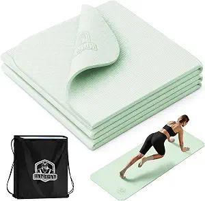 A man kneels on the HAPBEAR foldable mint yoga mat during a living room session.