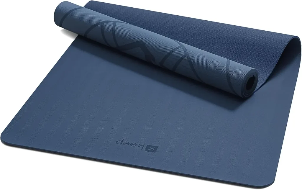 The KEEP extra wide and long yoga mat in navy blue lies half rolled to show its dense TPE surface.