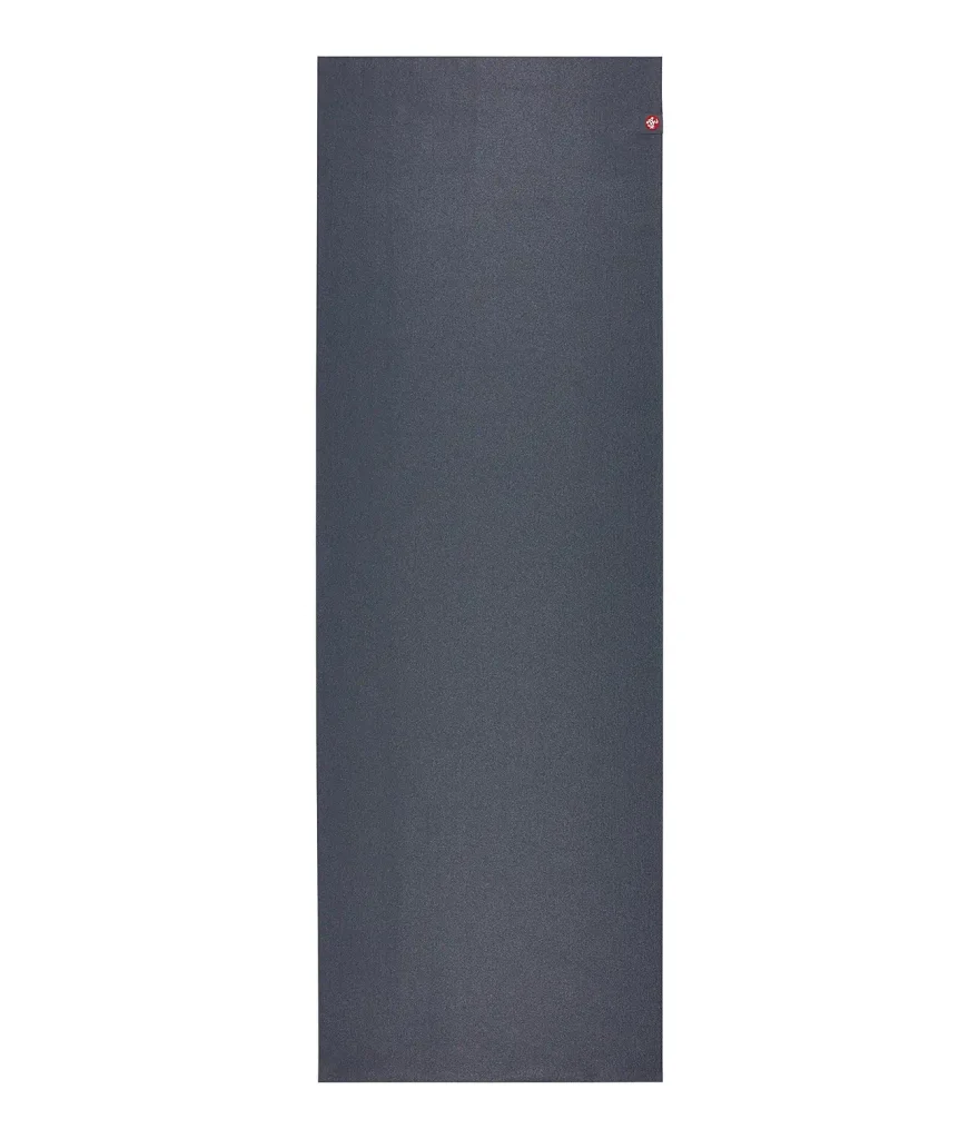 The Manduka eKO SuperLite in charcoal lies folded flat with its natural rubber surface facing up.
