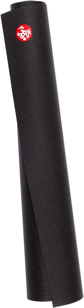 The Manduka PRO travel mat in black folds into a compact square with the brand dot at its corner.