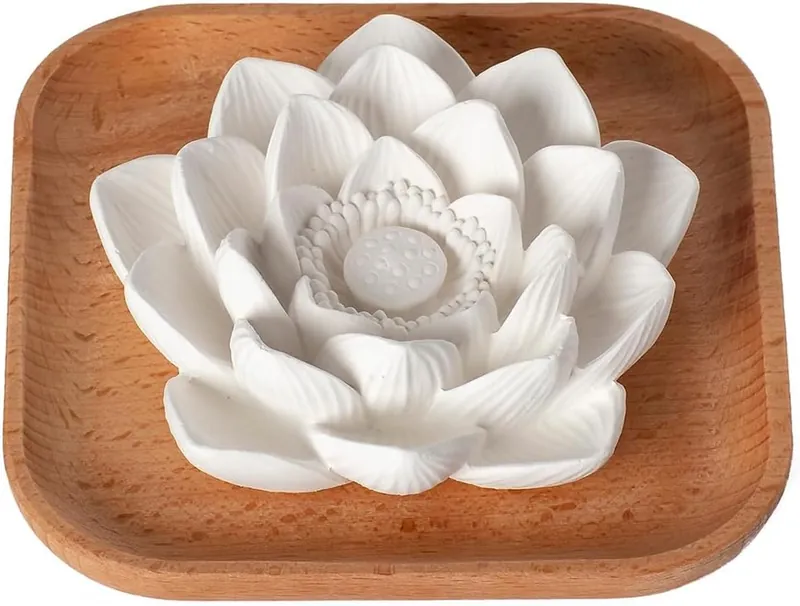 carved white plaster lotus resting in a square wooden tray