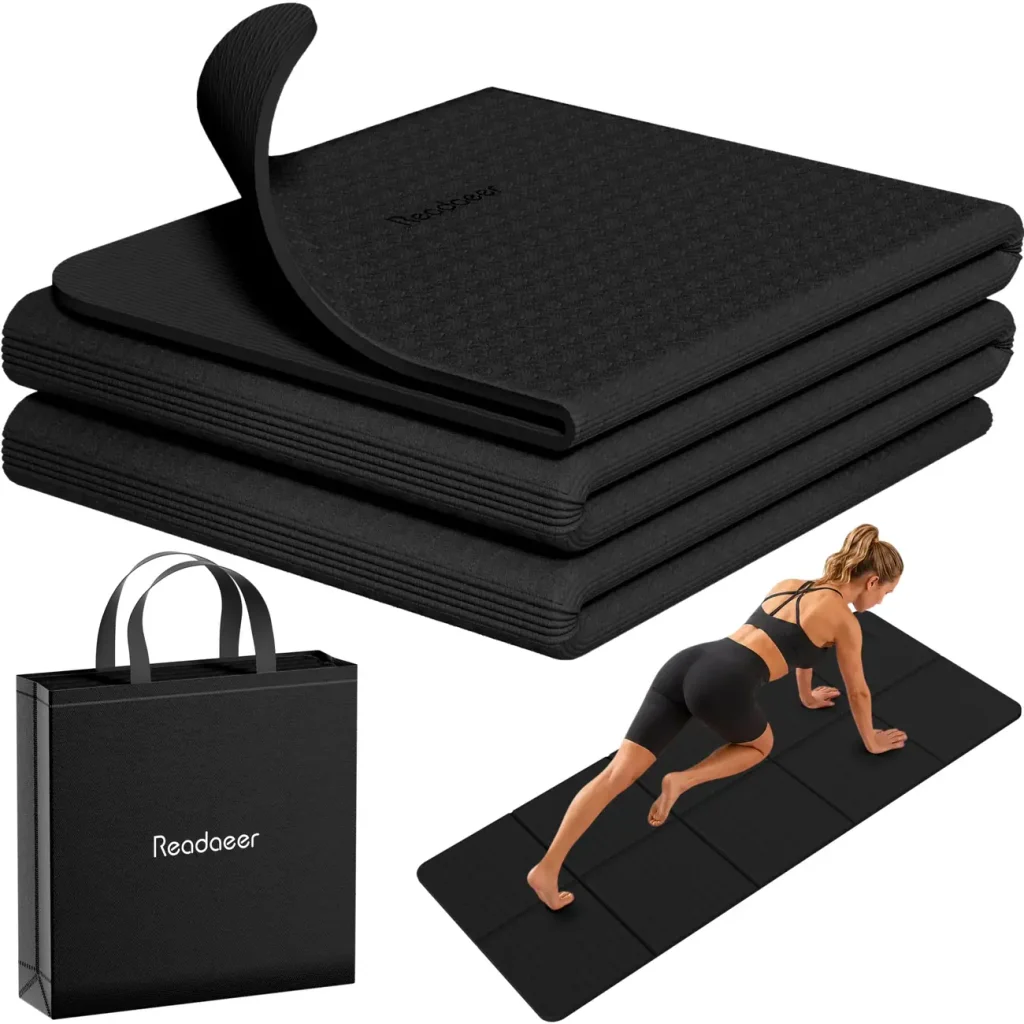 A Readaeer foldable yoga mat sits stacked in tight folds beside its zippered carry bag.