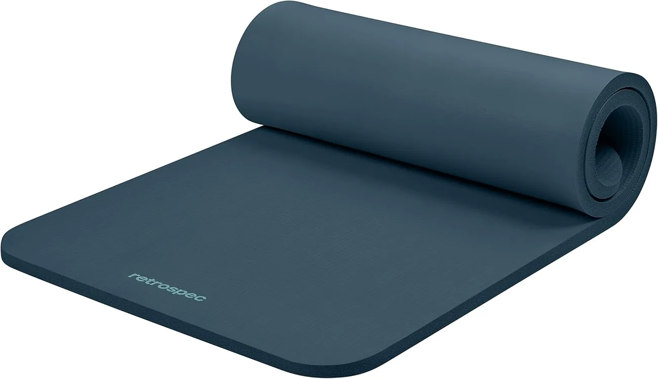 The Retrospec Solana one inch mat in ocean blue lies half rolled showing its ribbed high density foam.